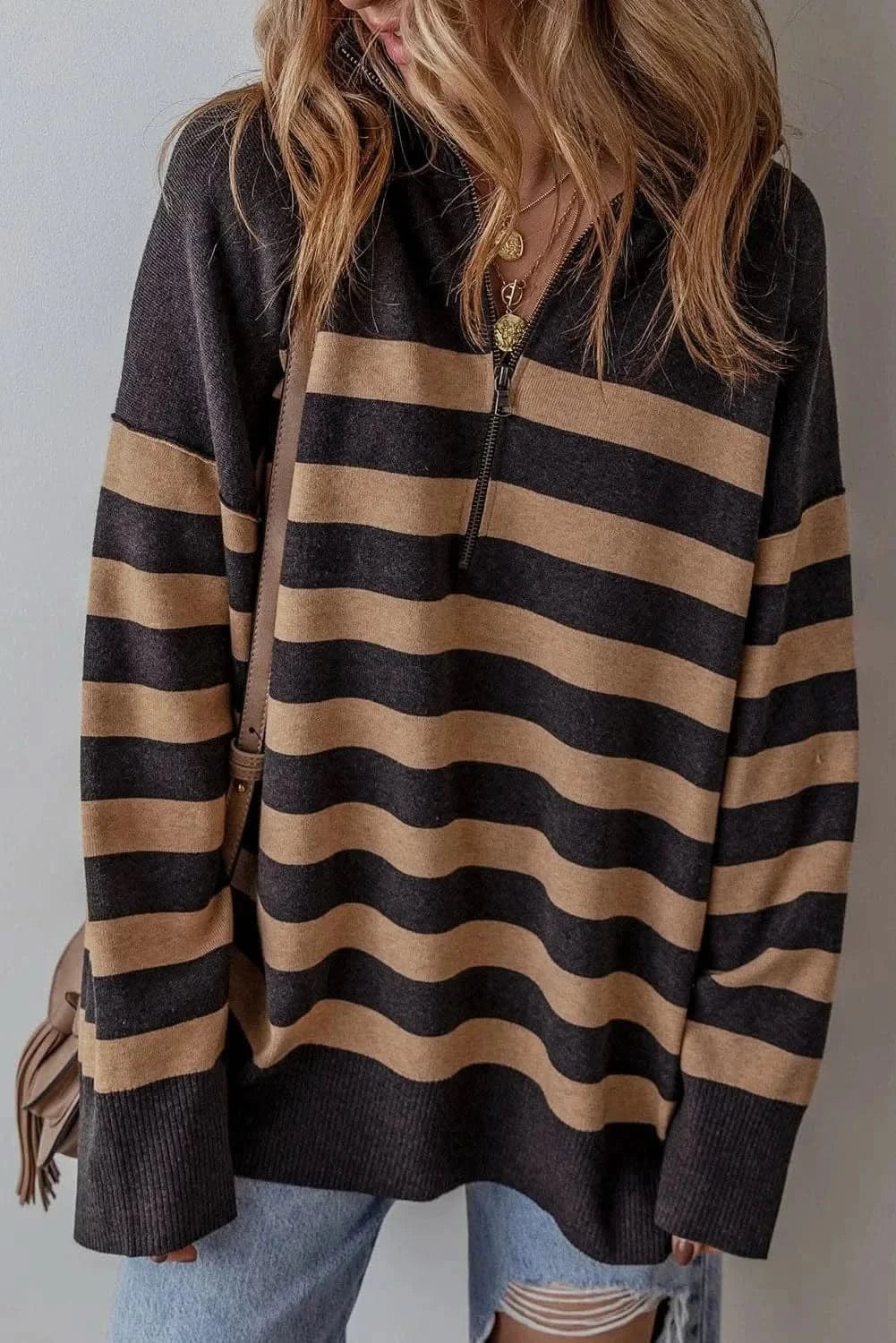 Striped half zip long sleeve knit top with beige and black bands.