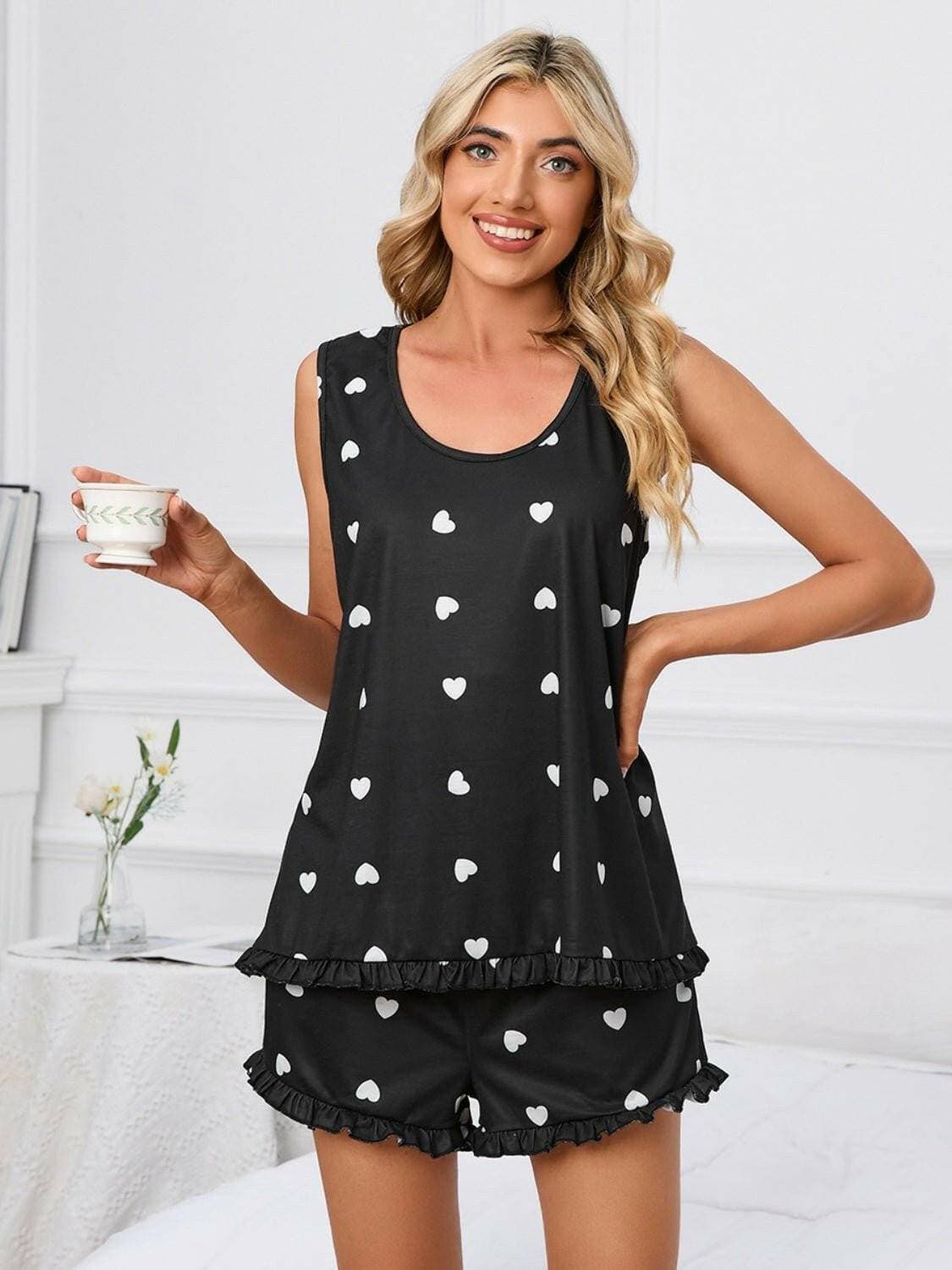 Heart print tank and shorts lounge set with scoop neck, worn by a smiling woman holding a cup.